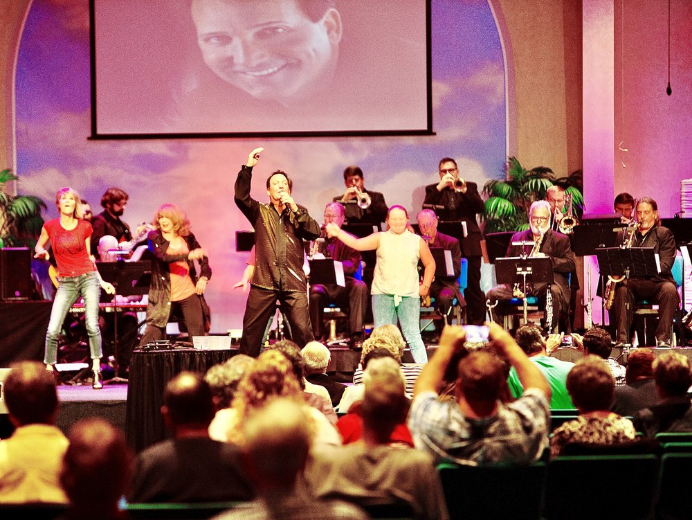 Billy Donato performing with band and dancers