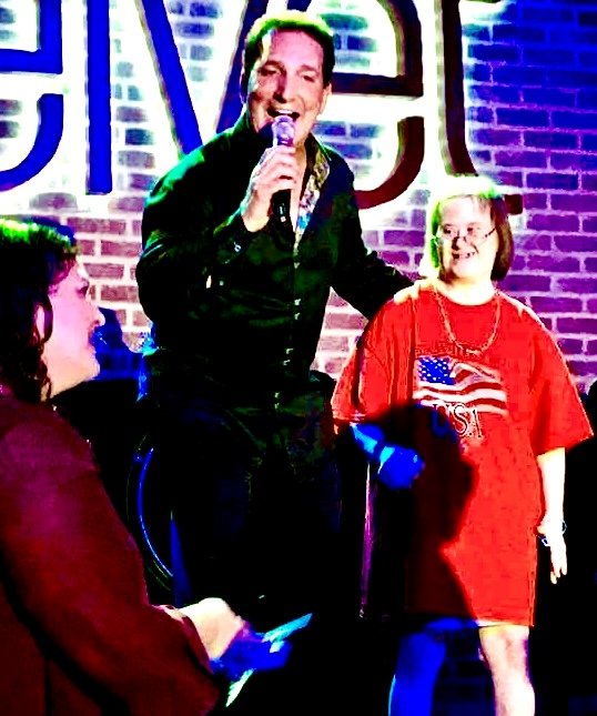 Billy Donato on stage with a fan